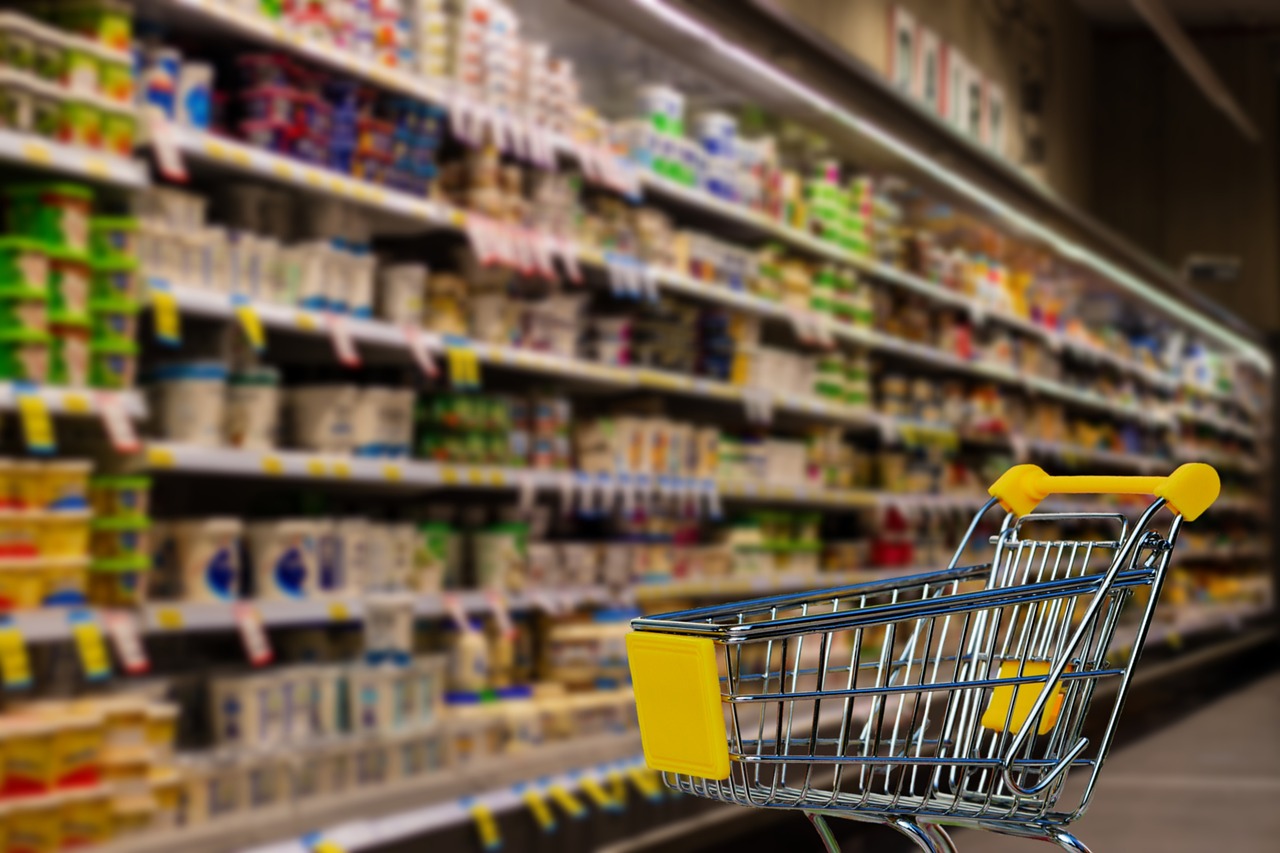 「スーパーにある商品棚とカート」の画像